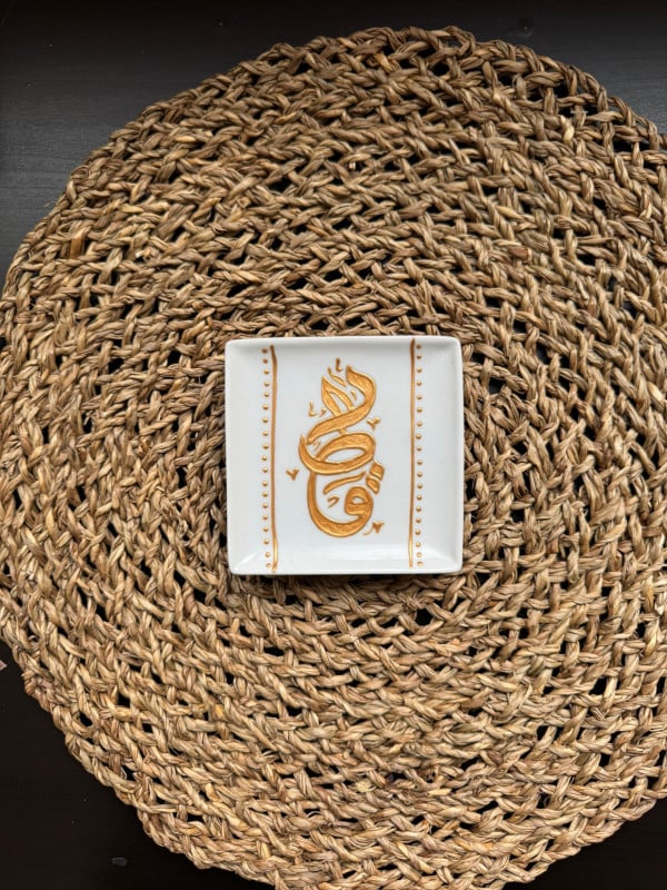 A glass magnet with a "Qatar" design