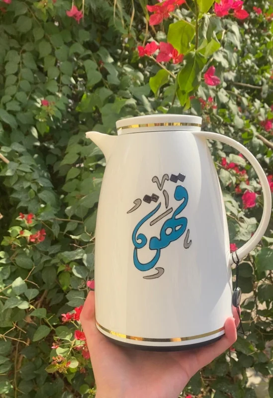 A sleek white thermos adorned with the word Coffee