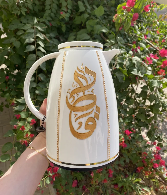 A luxurious white thermos adorned with the word "Qatar"